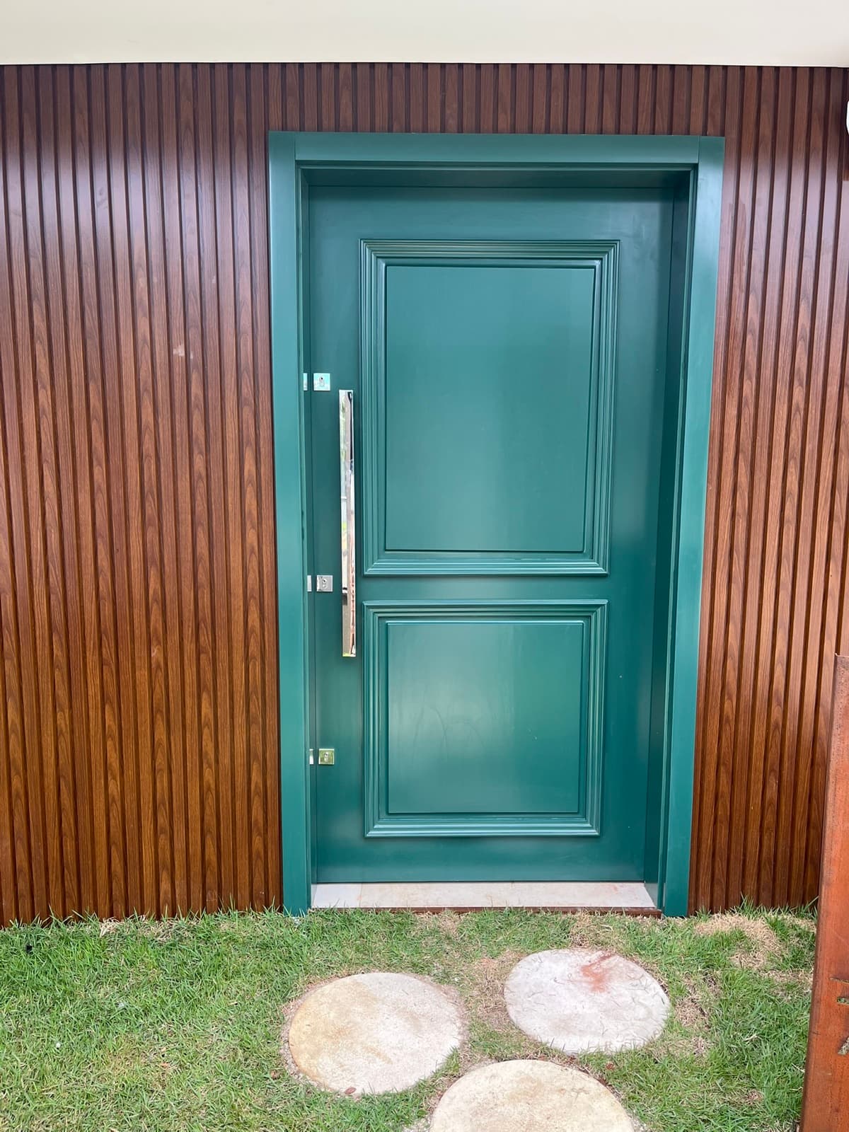 Porta verde com painel ripado amadeirado